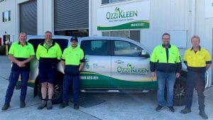 Staff of MG Roberts Plumbing pose outside their office with company branded ute behind